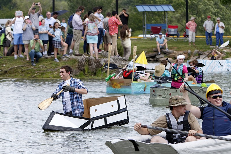 Forrest Webb, left, and others take part in the 23rd annual Physics Boat Day race at "Lake Buccaneer" on the campus of Boyd Buchanan School on Wednesday, May 8, 2019 in Chattanooga, Tenn. Students built boats out of cardboard and duct tape and raced them.