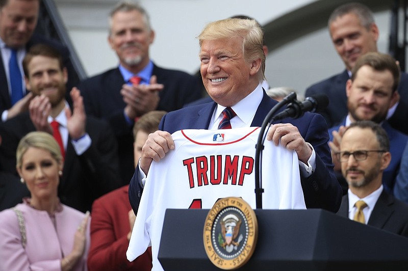 President Donald Trump shows off a Red Sox jersey presented to him during a ceremony welcoming the Boston Red Sox the 2018 World Series baseball champions to the White House, Thursday, May 9, 2019, in Washington. (AP Photo/Manuel Balce Ceneta)