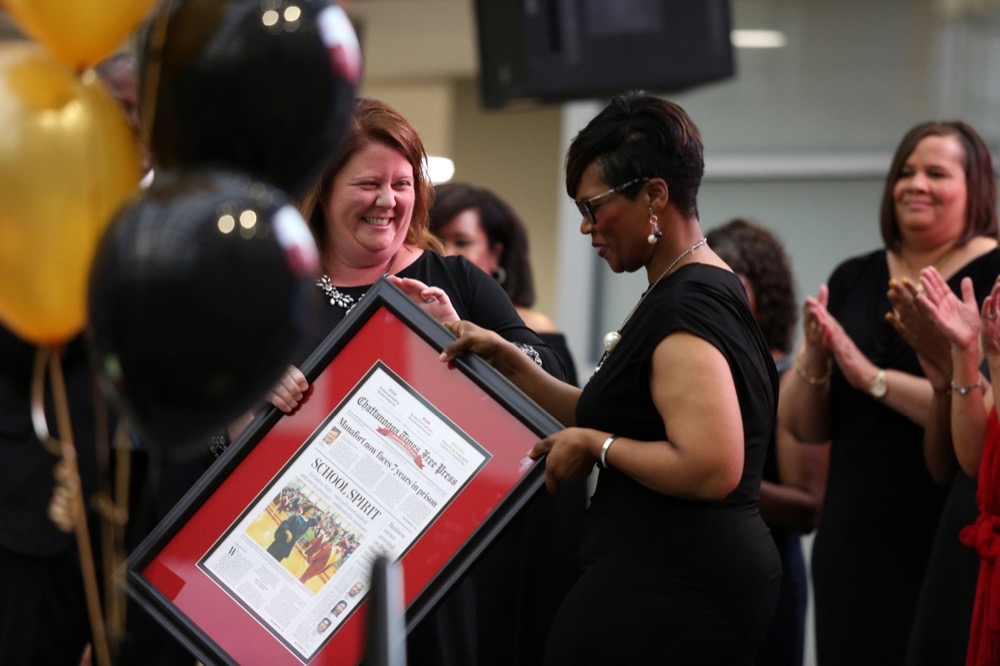 Jill Levine gives the principal of the year, The Howard School's Le Andrea Ware, a framed copy of the newspaper featuring Ware on the front page during the OZcars Gala Friday, May 10, 2019 at Unum in Chattanooga, Tennessee. The event was held for the Opportunity Zone schools in Hamilton County to celebrate educators who have gone above and beyond to help students succeed.