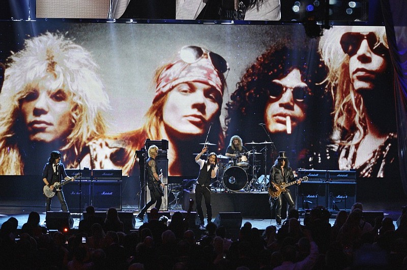 FILE - In this April 15, 2012, file photo, Guns N' Roses performs with singer Myles Kennedy after their induction into the Rock and Roll Hall of Fame in Cleveland. The rock band is accusing a Colorado brewery of stealing their brand and piggybacking off their fame to sell beer and merchandise. The band filed a trademark infringement lawsuit Thursday, May 9, 2019, against Colorado-based Oskar Blues Brewery, which sells Guns 'N' Ros beer and merchandise, including bandannas the group says is uniquely associated with singer Axl Rose. (AP Photo/Tony Dejak, File)

