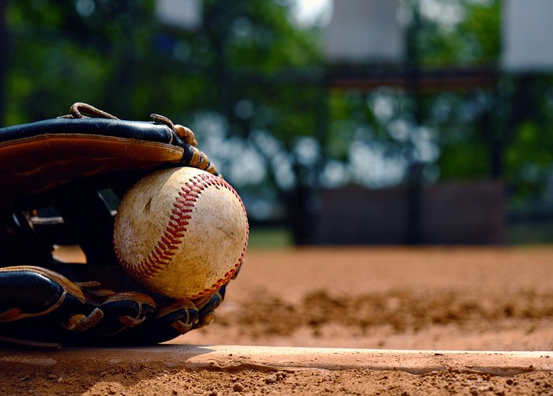 Baseball in glove laying on pitcher's mound of ball field. Old used sports equipment for team sport. baseball tile / Getty Images