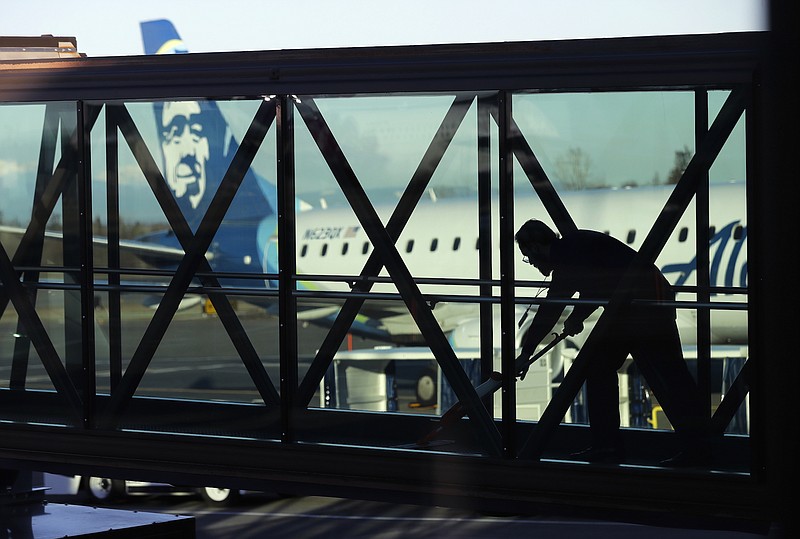 In this March 4, 2019, file photo, a worker cleans a jet bridge before passengers boarded an Alaska Airlines flight to Portland, Ore., at Paine Field in Everett, Wash. U.S. employers had a solid month of job growth in April, buoyed by a resilient economy that has confounded concerns that 2019 would begin with a slowdown. (AP Photo/Ted S. Warren, File)