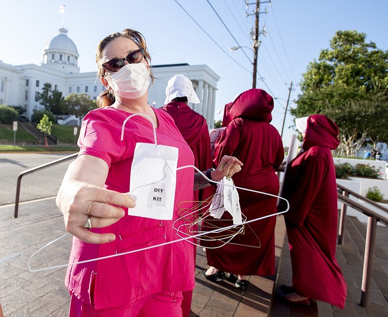 Laura Stiller hands out coat hangers as she talks about illegal abortions during a rally against HB314, the near-total ban on abortion bill, outside of the Alabama State House in Montgomery, Ala., on Tuesday, May 14, 2019. (Mickey Welsh/The Montgomery Advertiser via AP)

