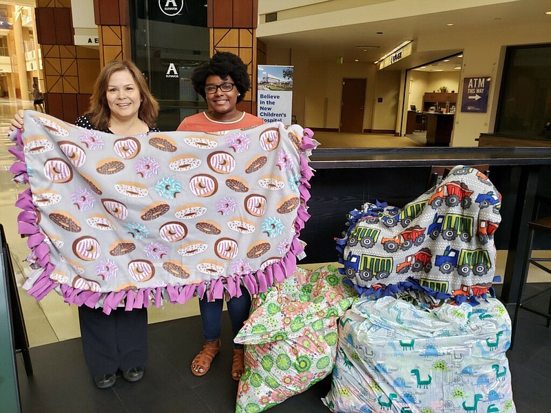 Kendal Lowe, right, donates handmade blankets to Erlanger hospital's mother-baby unit. Accepting the donation is Emilia Jones, director of volunteer services at Erlanger. / Contributed photo by Michelle Lowe (Kendal's Mom.)