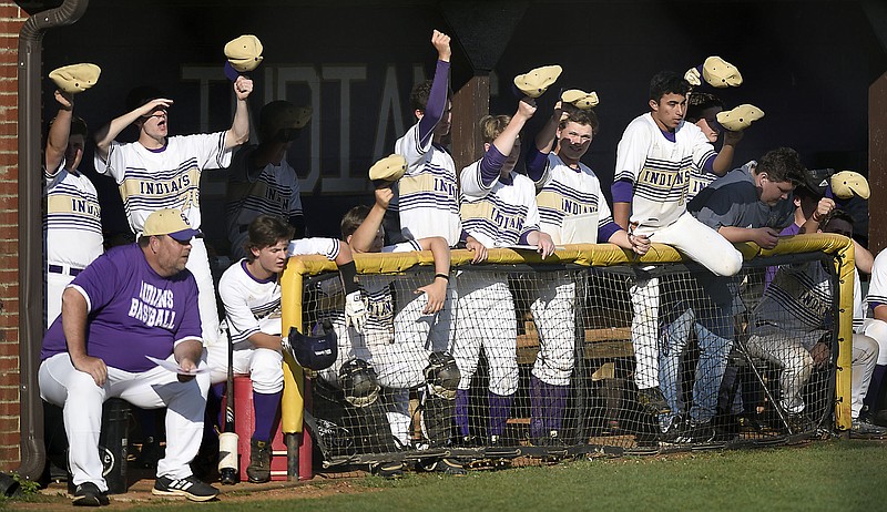 Baseball players in the Sequatchie County dugout shake their caps as they encourage their fellow Indians during the Region 4-AA title game against Grundy County on Wednesday night.