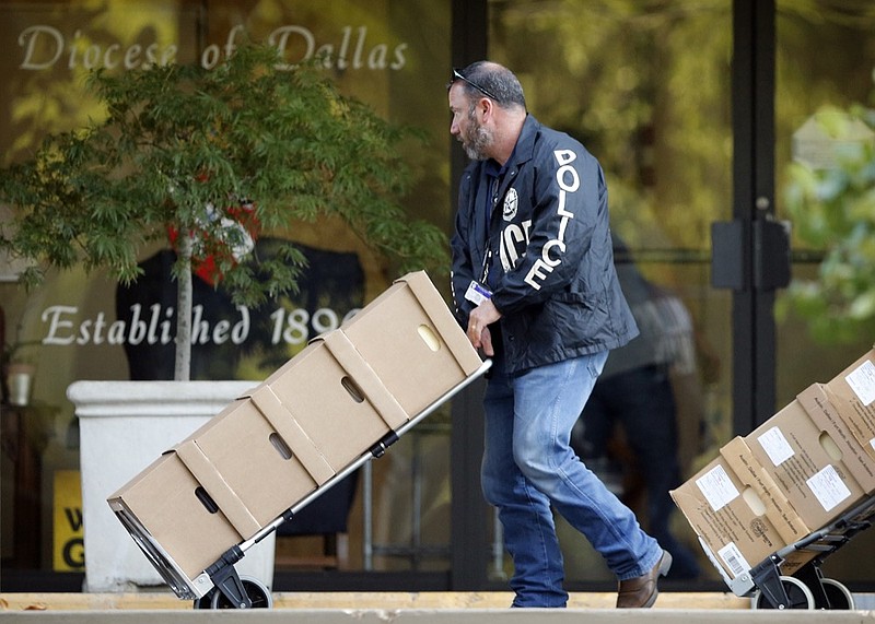 Authorities conduct a raid on the Catholic Diocese of Dallas, Wednesday, May 15, 2019. A police commander says a search at the Catholic Diocese of Dallas began when an investigation into child sexual abuse allegations against a former priest uncovered claims against others. (Tom Fox/The Dallas Morning News via AP)

