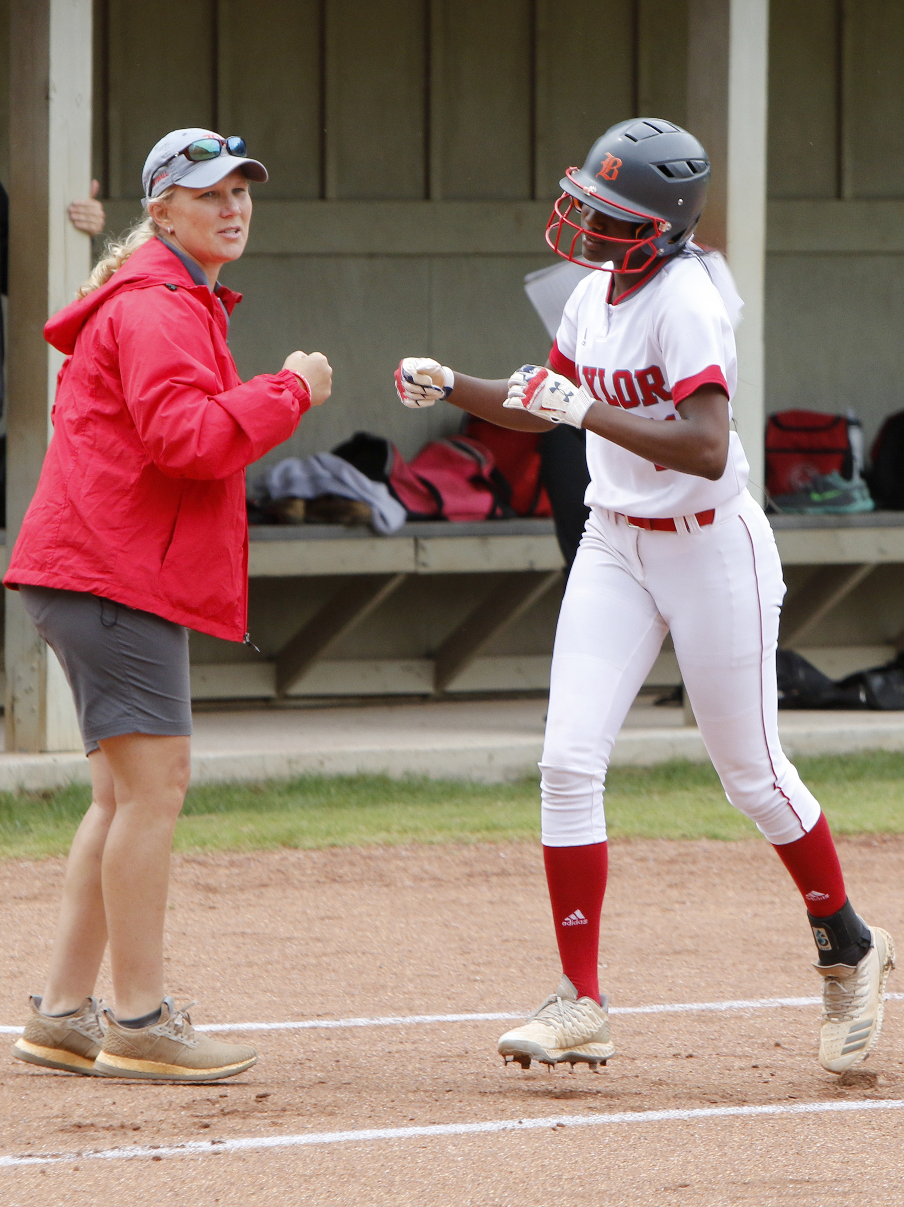 Baylor's Makayla Packer (11) fist bumps Coach Kelli Smith while rounding third base after hitting a 3-run home run in the bottom of the first inning during Game 1 of a doubleheader in the Division II-AA quarterfinals against St. Cecilia Academy at Baylor School on Wednesday, May 15, 2019 in Chattanooga, Tenn. Baylor won 16-0 in three innings.