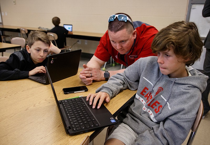 Teacher Joshua Payne, center, helps Nicolas Johnson, left, and Gray McLean as they complete Learning Blade exercises in a 7th grade STEM innovators class at Signal Mountain Middle High School on Thursday, May 9, 2019, in Signal Mountain, Tenn. Learning Blade presented a 3D printer to the school for their achievement using the Learning Blade program.