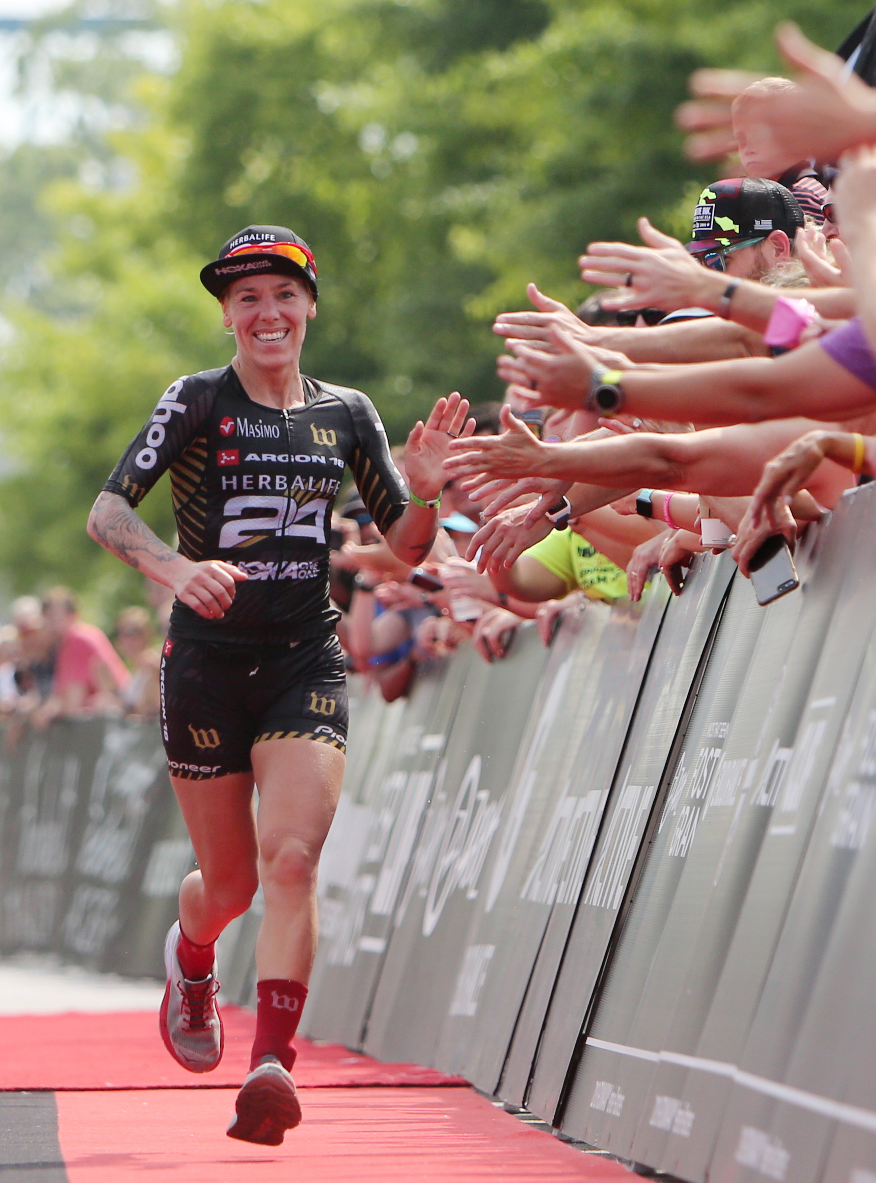 Heather Jackson receives high fives from onlookers as she finishes first during Ironman 70.3 Chattanooga Sunday, May 20, 2018 in Chattanooga, Tenn. Jackson finished with a time of 4:11:08.
