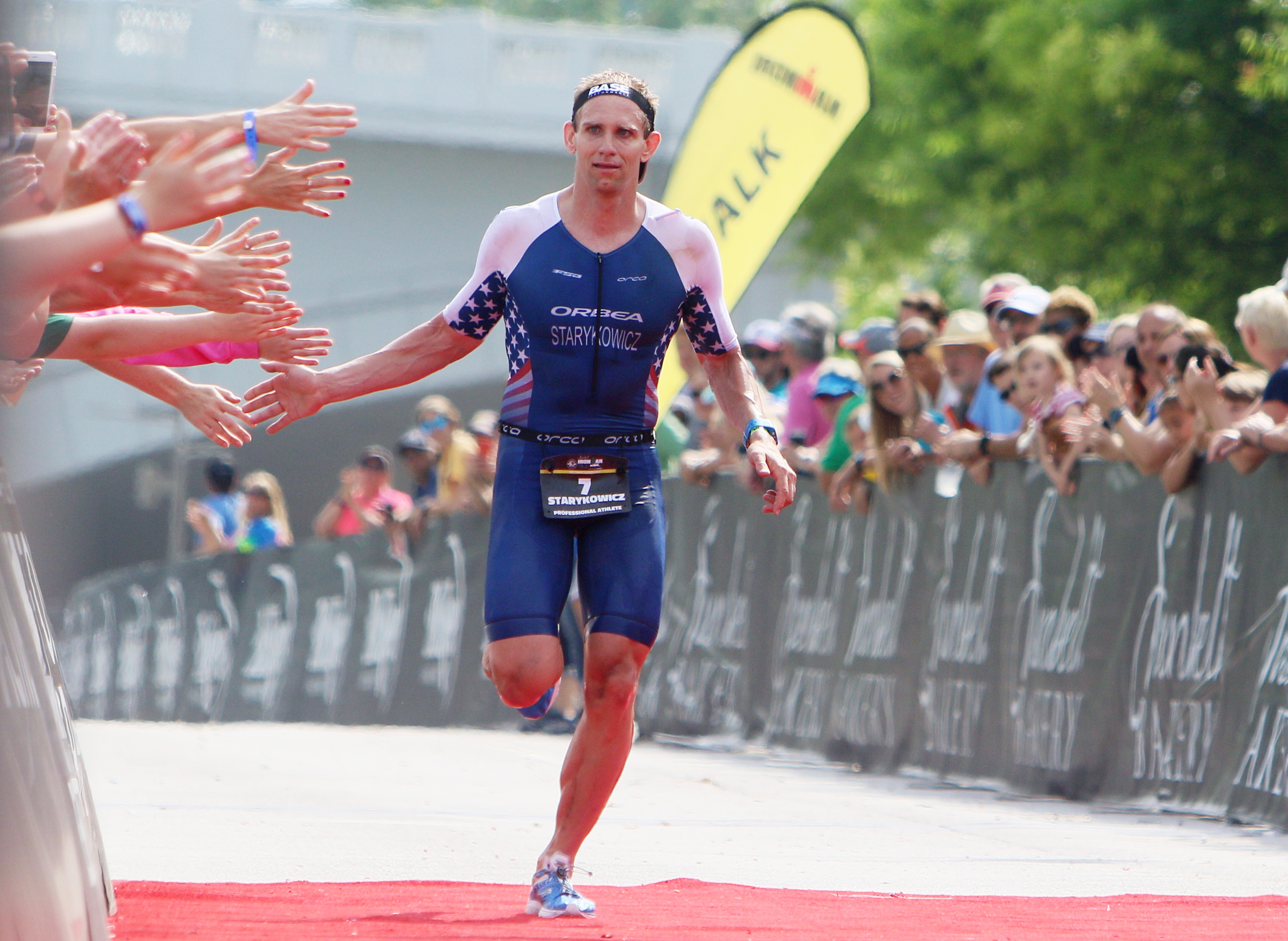 Andrew Starykowicz receives high fives as he nears the finish line during Ironman 70.3 Chattanooga Sunday, May 20, 2018 in Chattanooga, Tenn. Starykowicz placed first with a time of 3:46:28.