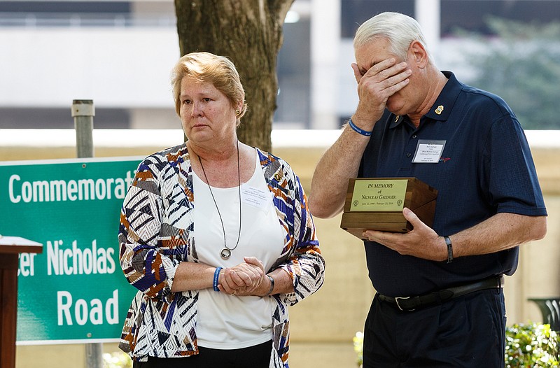 Barry Galinger, right, and Gretchen Galinger, parents of Chattanooga Police Officer Nicholas Galinger, react to the commemoration of a road in Nicholas's honor during the annual Law Enforcement Memorial Ceremony on Market Street on Thursday, May 16, 2019, in Chattanooga, Tenn. The ceremony honors fallen first responders from the area's law enforcement agencies in conjunction with National Police Week.