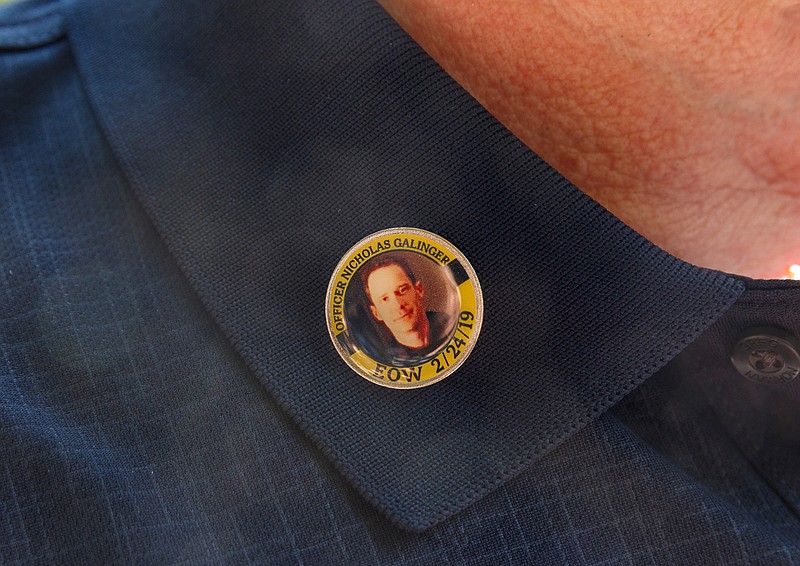 Barry Galinger, father of Chattanooga Police Officer Nicholas Galinger, wears a pin in his son's honor during the annual Law Enforcement Memorial Ceremony on Market Street on Thursday, May 16, 2019, in Chattanooga, Tenn. The ceremony honors fallen first responders from the area's law enforcement agencies in conjunction with National Police Week.