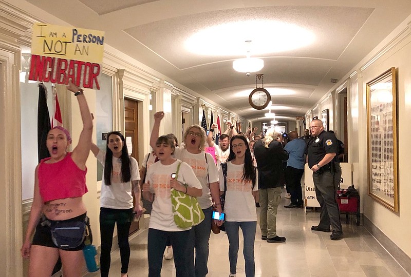 Protesters march through the halls of the Missouri Capitol outside the House chamber on Friday, May 17, 2019, in Jefferson City, Missouri, in opposition to legislation prohibiting abortions at eight weeks of pregnancy. Missouri's Republican-led Legislature has passed a sweeping bill to ban abortions at eight weeks of pregnancy, and Republican Gov. Mike Parson is expected to sign it. The House approved the measure Friday May 17, 2019. (AP Photo/David A. Lieb)