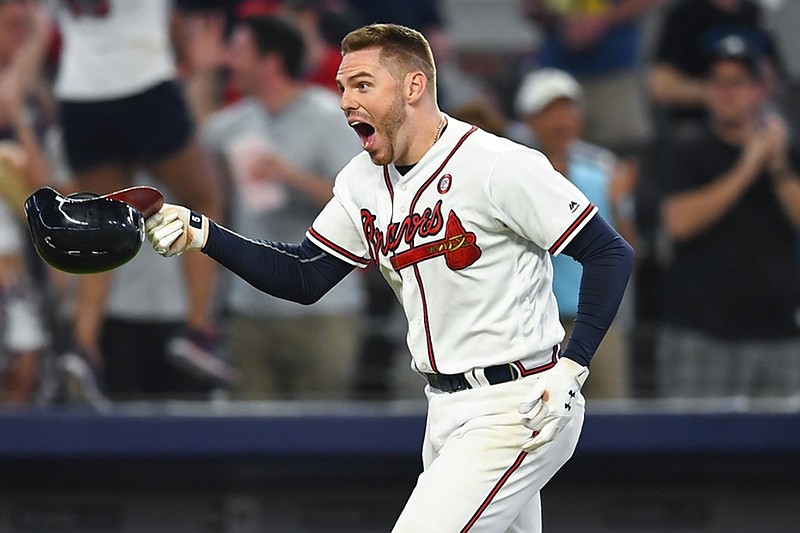 Atlanta Braves first baseman Freddie Freeman celebrates his game-winning home run against the Milwaukee Brewers as he heads toward the plate in the 10th inning Saturday night in Atlanta. The Braves won 4-3.