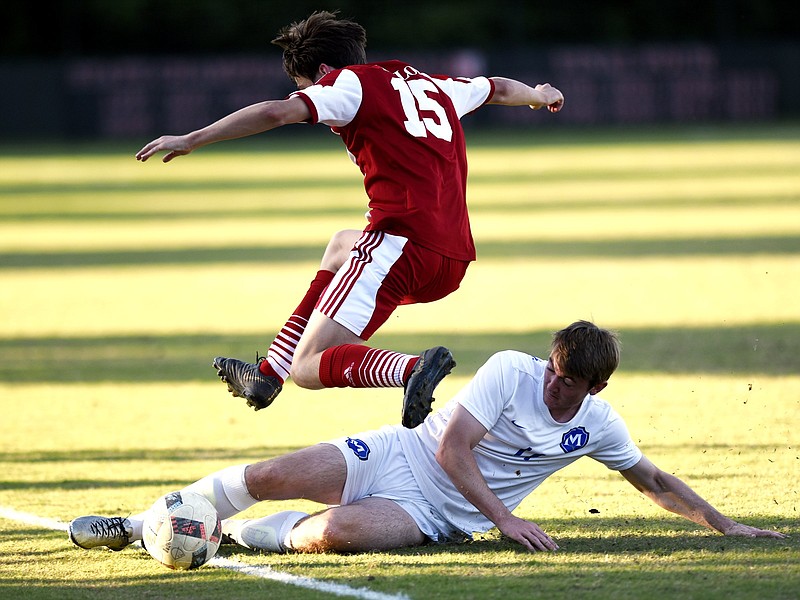 McCallie's Matthew Warbrick (14) does a sliding tackle to knock the ball away from Baylor's Hunter miller (15).  The McCallie Blue Tornado visited the Baylor Red Raiders in TSSAA soccer action on April 26, 2019.