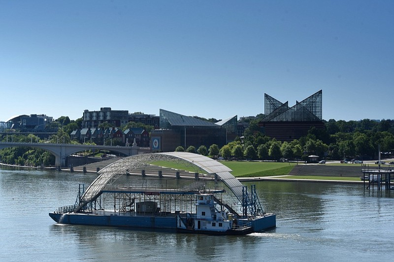 The Dolphin tow boat motors upstream with the familiar Riverbend Festival's Coca-Cola stage Tuesday morning is route to its performance resting place for the 2019 Riverbend Festival.  / Staff photo by Tim Barber 
