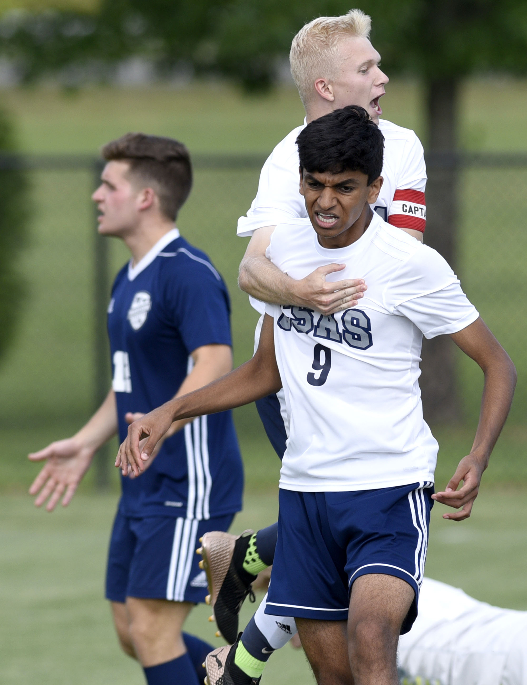 Arts & Sciences soccer player James Badger leaps on the back of teammate Rohit Krishnamoorty (9) after Krishanmoorty scored a goal during a Class A state tournament match against Madison Magnet on Tuesday at the Richard Siegel Soccer Complex in Murfreesboro, Tenn. Krishanmoorty scored twice to help his team win 4-1.
