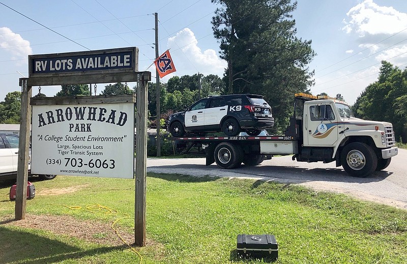 A tow truck removes a police car from a mobile home park, Monday, May 20, 2019, in Auburn, Ala., where three police officers were shot late Sunday. Authorities say a man opened fire on police responding to a domestic call late Sunday, killing one officer and wounding two others. (AP Photo/Blake Paterson)

