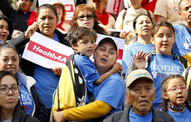 Oralia Sandoval, center, holds her son Benjamin, 6, as she participates in an Immigrants Day of Action rally, Monday, May 20, 2019, in Sacramento, Calif. Gov. Gavin Newsom has proposed offering government-funded health care benefits to immigrant adults ages 19 to 25 who are living in the country illegally. State Sen. Maria Elena Durazo, D-Los Angeles, has proposed a bill to expand that further to include seniors age 65 and older. (AP Photo/Rich Pedroncelli)

