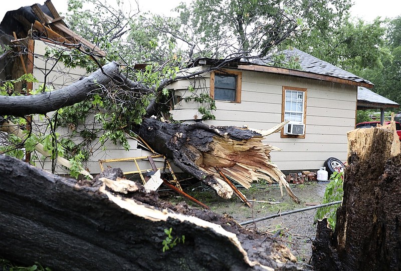 A large tree rests inside a home where a man was rescued near Newton and St. Louis Avenue in Tulsa, Okla., on Tuesday, May 21, 2019. (Tom Gilbert/Tulsa World via AP)