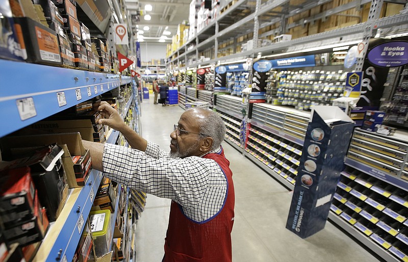 FILE - In this Feb. 23, 2018 photo sales associate Larry Wardford, of Holliston, Mass., places items on selves at a Lowe's retail home improvement and appliance store, in Framingham, Mass. Lowe's Companies Inc. reports earnings on Wednesday, May 22, 2019. (AP Photo/Steven Senne, File)