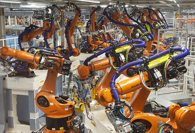 In this Tuesday, May 14, 2019 photo, robot arms stand at the assembly line during the reconstruction for the electrical car body construction at a press tour at the plant of the German manufacturer Volkswagen AG (VW) in Zwickau, Germany. Volkswagen will total shift into electric cars at the plant in Zwickau and the first vehicles are to roll off the assembly line at the end of 2019. (AP Photo/Jens Meyer)