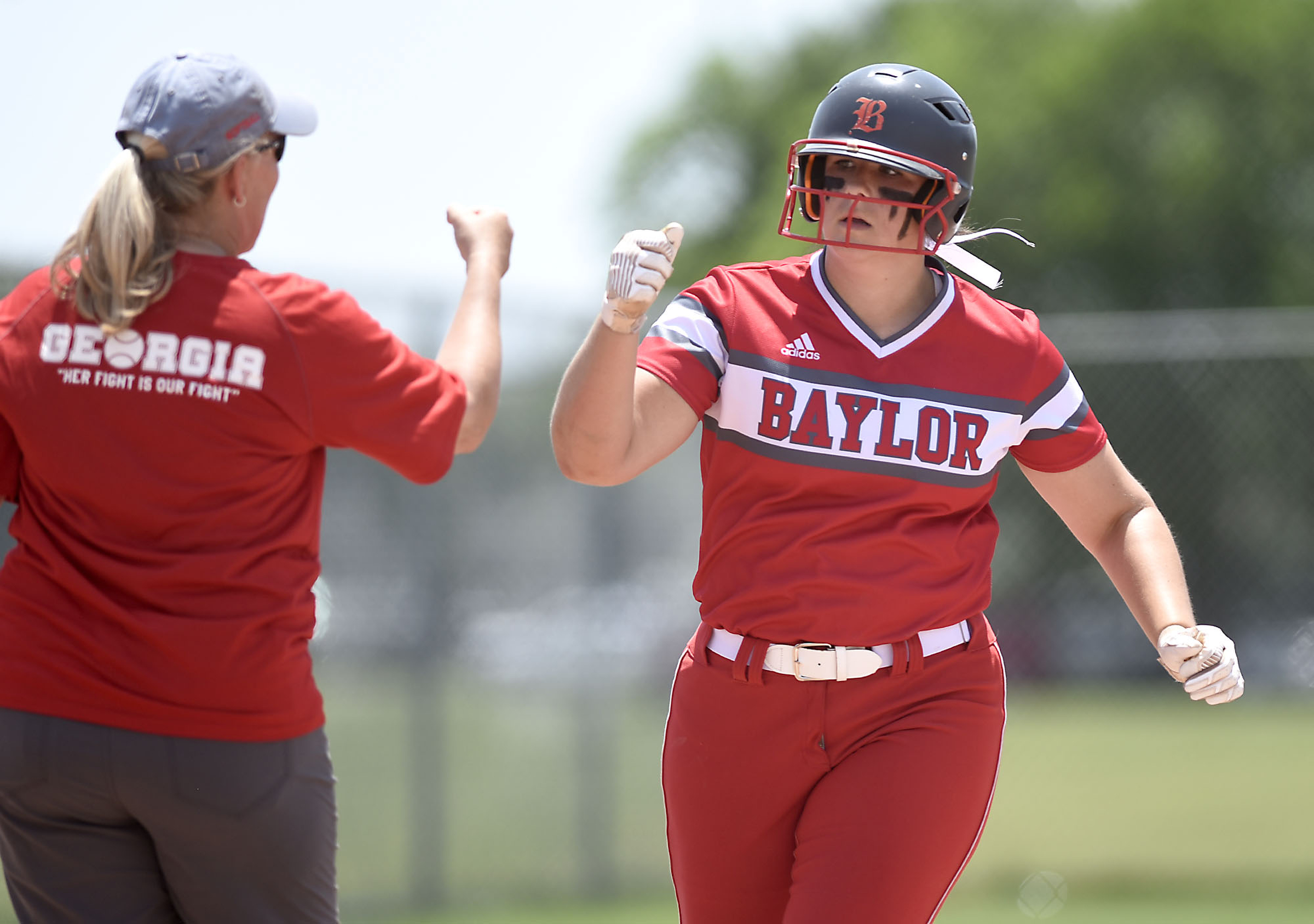 Baylor's Macy McKnight (20) is congratulated by head coach Kelli Smith, as McKnight rounds third after hitting a home run. GPS faced Baylor in the semifinals of the TSSAA Division II Class AA State Girls's softball tournament at McKnight Fields on May 22, 2019.
