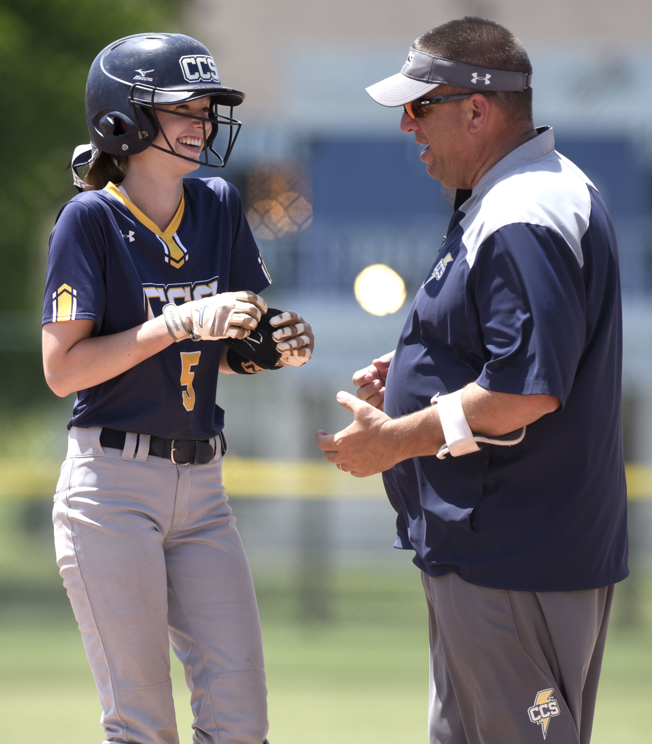 CCS's Madison Blevins (5) shares a laugh, after hitting a single, with frist base coach Brent Matthews. Chattanooga Christian faced Davidson Academy in the quarterfinals of the TSSAA Division II Class A state girls's softball tournament held at the Starplex in Murfreesboro on May 22, 2019.
