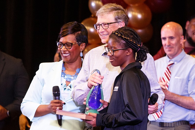 Laila Smith, recipient of the Resilient Student Award, poses for photos on stage with billionaire tech mogul and Microsoft co-founder Bill Gates, center, and Howard School Principal LeAndrea Ware, left, in the auditorium at The Howard School during their awards day program on Thursday, May 23, 2019 in Chattanooga, Tenn.