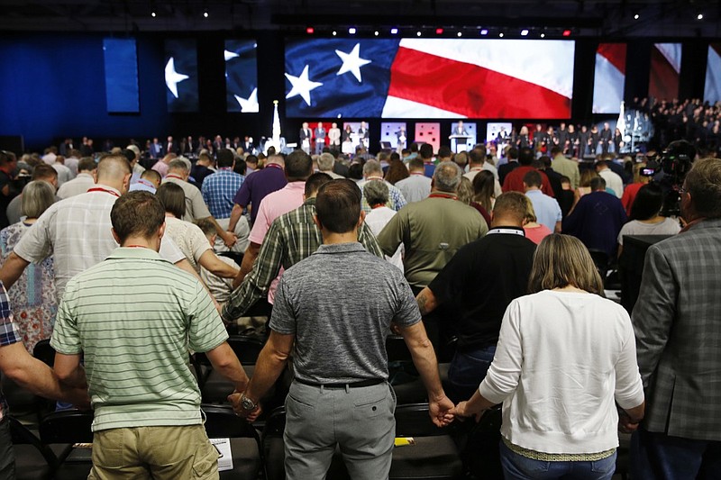 In this June 12, 2018 file photo, people pray for America at the 2018 annual meeting of the Southern Baptist Convention at the Kay Bailey Hutchison Dallas Convention Center in Dallas. The nation's largest Protestant denomination is reporting its twelfth year of declining memberships. On Thursday, May 23, 2019, the Southern Baptist Convention reported total membership for 2018 at 14.8 million, down about 192,000 from the previous year. (Vernon Bryant/The Dallas Morning News via AP, File)