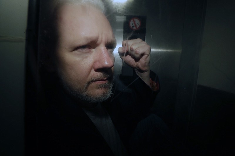 In this May 1, 2019, file photo, WikiLeaks founder Julian Assange puts his fist up as he is taken from court in London. The Justice Department has charged Assange with receiving and publishing classified information. The charges are contained in a new, 18-count indictment announced May 23, 2019. (AP Photo/Matt Dunham, File)
