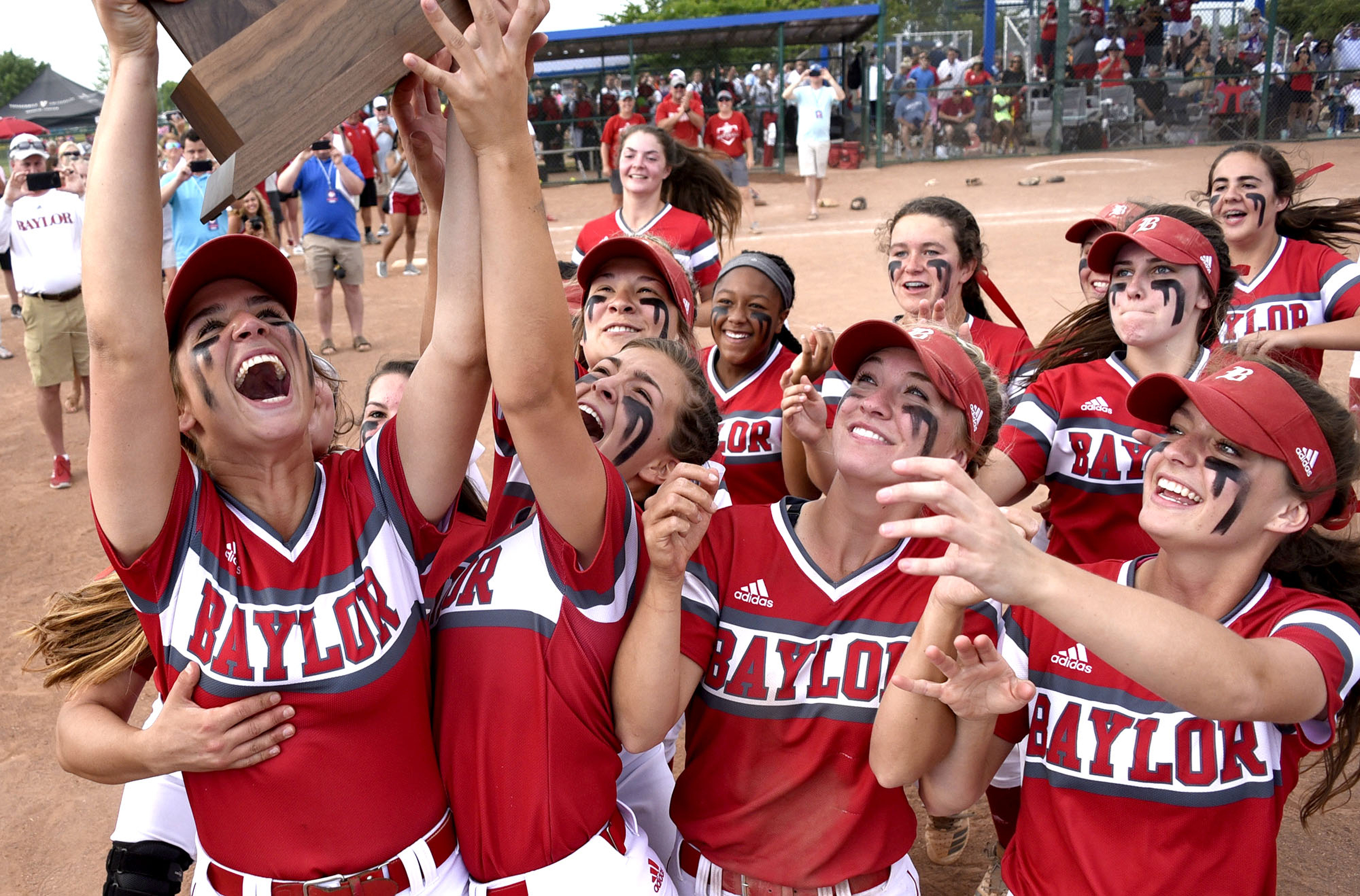 Baylor's Brinley Garrison (12) holds the trophy high as the Lady Raiders celebrate their state championship. Baylor defeated GPS 2-1 for the TSSAA Division II Class AA softball championship at the Starplex in Murfreesboro on May 23, 2019. .