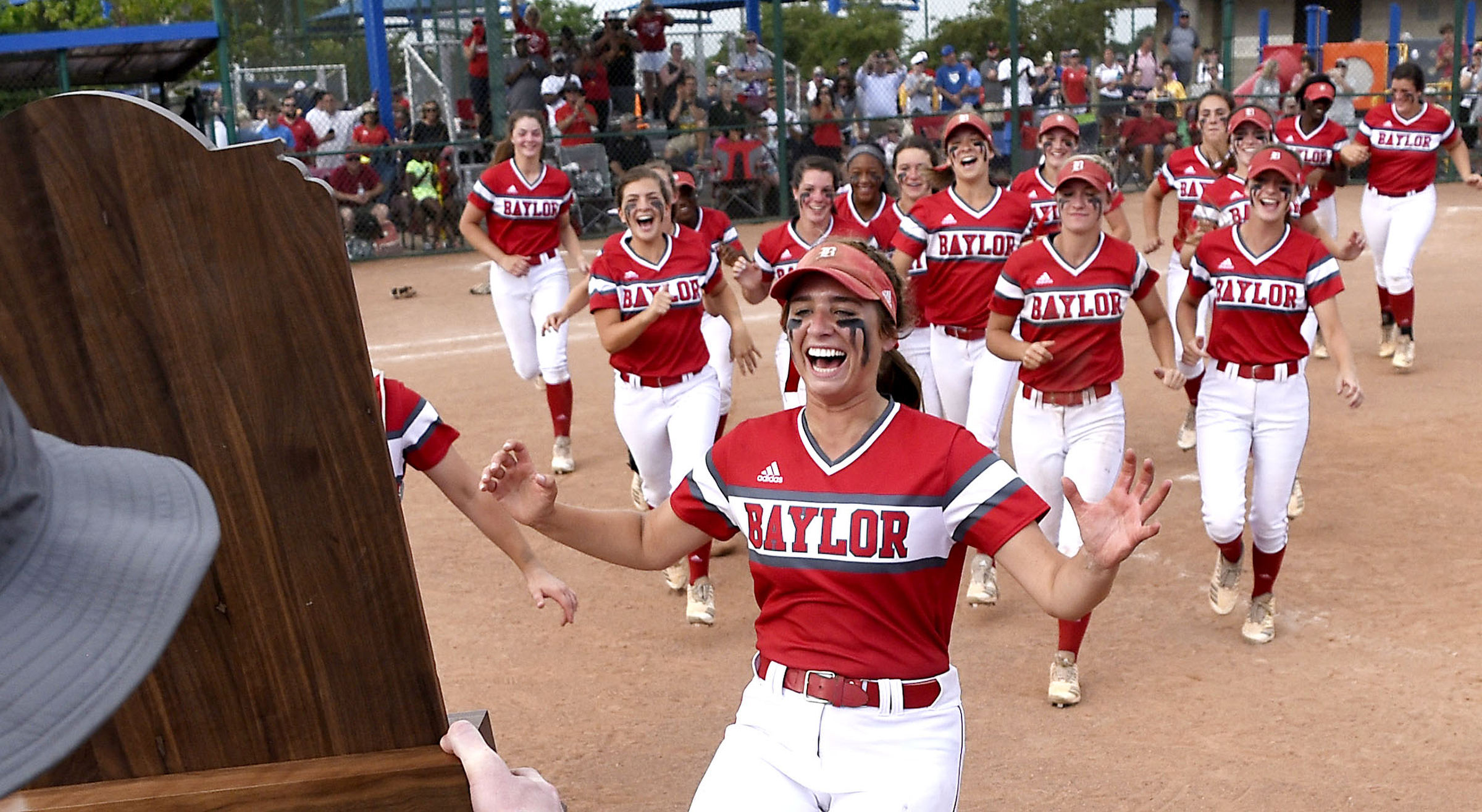 Baylor seniors Abby McNamara (3), obscured by the trophy, and Brinley Garrison (12) lead the Lady Red Raiders to claim the championship trophy. Baylor defeated GPS 2-1 for the TSSAA Division II Class AA softball championship at the Starplex in Murfreesboro on May 23, 2019. .
