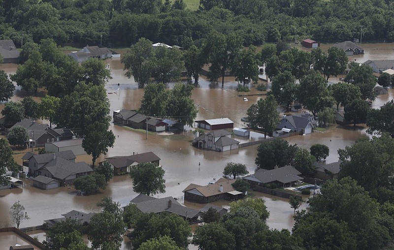 In this aerial image, homes are inundated with flood waters from the Arkansas River near South 145th West Ave near Highway 51 on Thursday, May 23, 2019, in Sand Springs, Okla. Storms and torrential rains have ravaged the Midwest, from Texas through Oklahoma, Kansas, Nebraska, Iowa, Missouri and Illinois, in the past few days. (Tom Gilbert/Tulsa World via AP)

