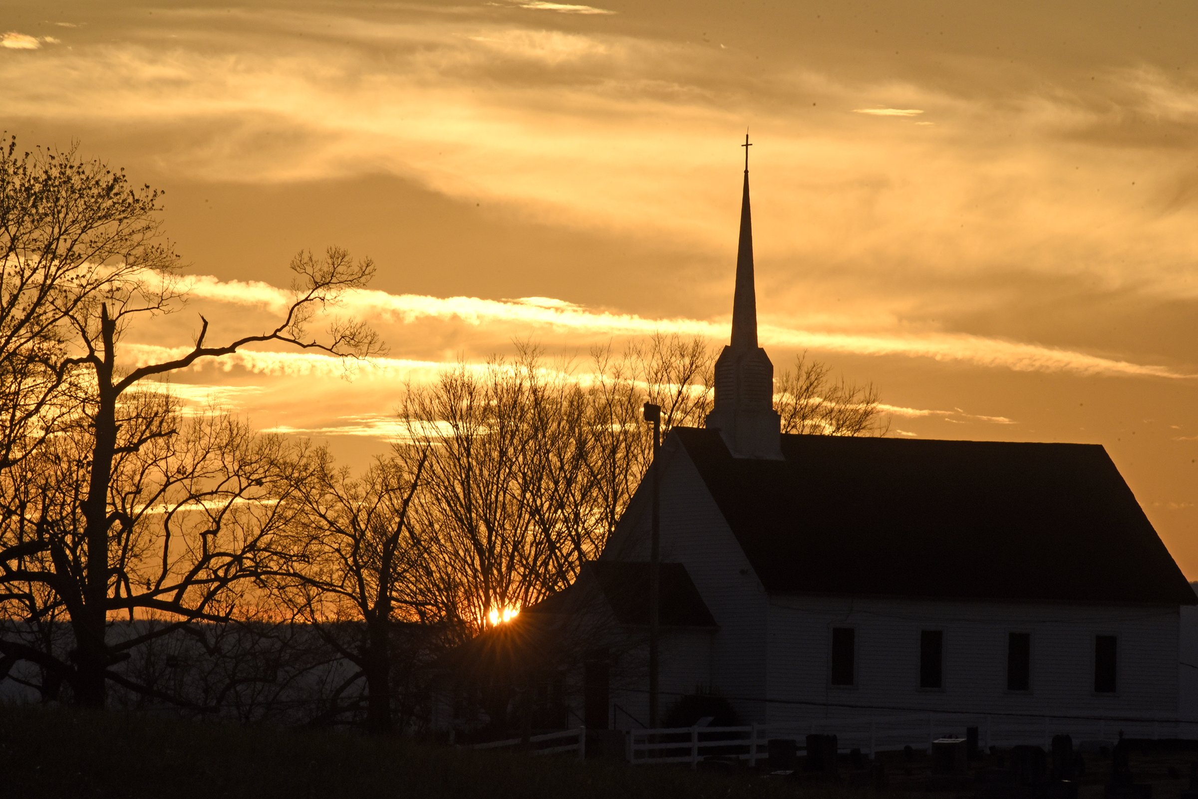The sun sets behind the Cumberland Plateau as Chapel Hill United Methodist Church and the surrounding trees stand in the foreground. The site has been a center for religious practice on the East Valley Road, east of Dunlap, in the Sequatchie Valley since 1851. The church can be seen along two cycling routes, the Daus Mountain Challenge and Middle Sequatchie Valley Loop, in a new database.