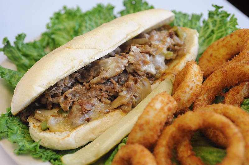 The Philly cheesesteak is sliced steak topped with melted cheese, mushrooms, onions and peppers on a hoagie roll.