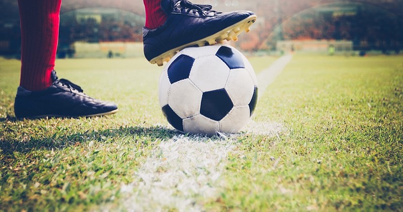 soccer or football player standing with ball on the field for Kick the soccer ball at football stadium soccer tile / Getty Images
