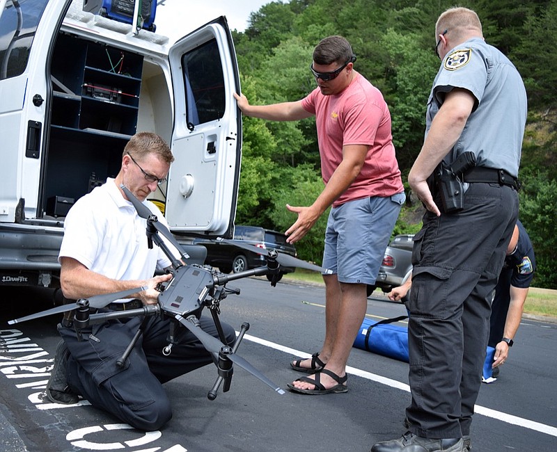 Staff photo by Mark Pace/Chattanooga Times Free Press — Marty Dunn, left, a Hamilton County Sheriff's Office special operations detective, prepares a drone to help in the search of a missing Cleveland man on the Ocoee River Tuesday, May 28, 2019. Polk County deputies Casey Hickman and Manuel Patterson, from left, also assist. 
