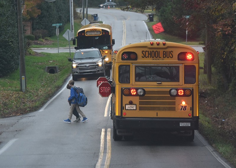 In this 2018 staff file photo, two children cross Gann Road in Middle Valley as they exit their school bus.