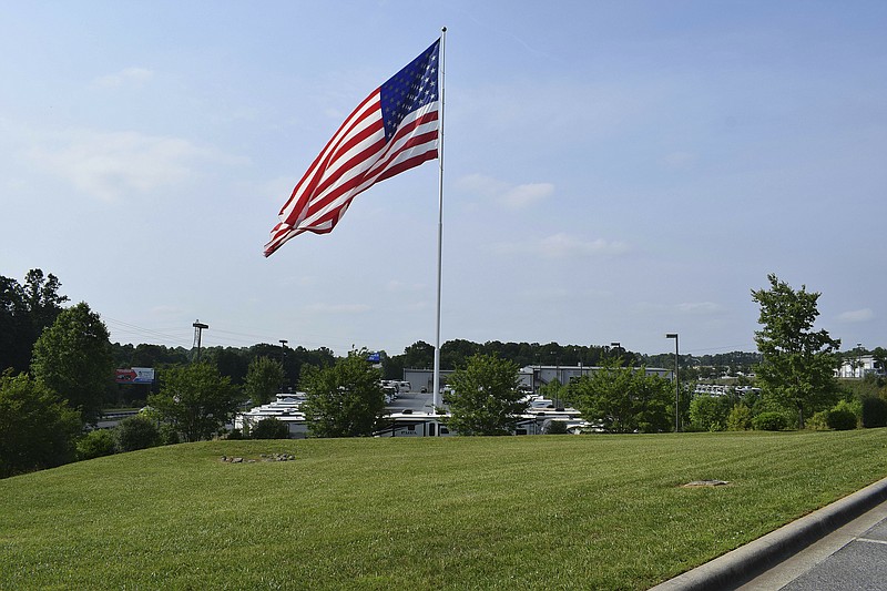 In this undated handout photo provided by Camping World, an American flag blows in the wind at Gander RV, in Statesville, N.C. Businessman and reality television star Marcus Lemonis says he'll go to jail before he removes a huge American flag flying at a recreational vehicle store that his company owns and that's the subject of a lawsuit because of its size. (Jennifer Munday/Camping World, AP)
