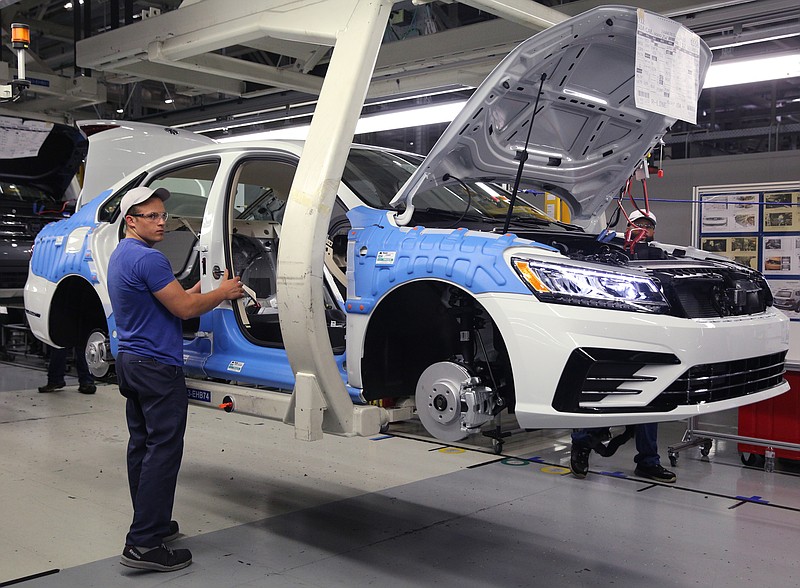 Staff file photo by Erin O. Smith / Volkswagen employees work around vehicles moving down the assembly line at the assembly plant in Chattanooga in this file photo.