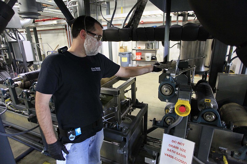 Lab technician Michael Evans checks the process as carbon fiber is manufactured at Oak Ridge National Laboratory's Carbon Fiber Technology Facility where research is being done to try and make the advanced material more affordable for mainstream use.