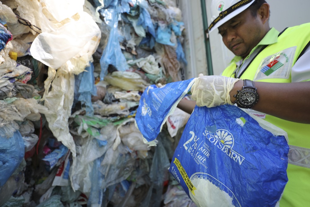 Officers from ministry of environment examining a container with full of non-recyclable plastic scraps which detained by authority's at westport in Klang, Malaysia, Tuesday, May 28, 2019. Malaysia environment minister Yeo Bee Yin says Malaysia has become a dumping ground for the world's plastic waste, and Malaysia has begun sending non-recyclable plastic scrap to the developed countries of origin.(AP Photo/Vincent Thian)