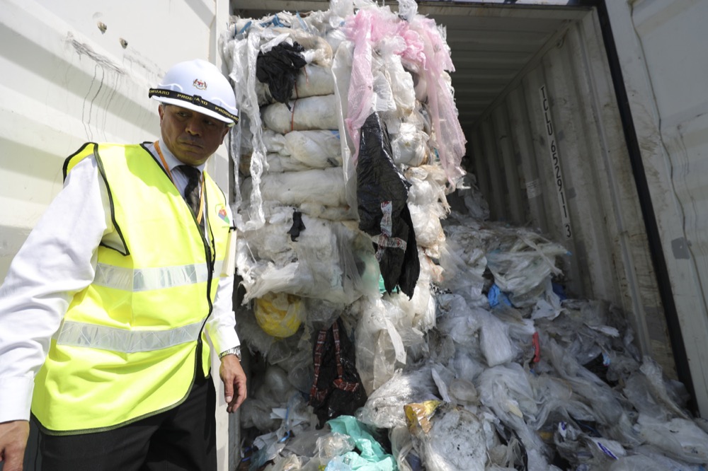 Officers from ministry of environment examining a container with full of non-recyclable plastic scraps which detained by authority's at westport in Klang, Malaysia, Tuesday, May 28, 2019. Malaysia environment minister Yeo Bee Yin says Malaysia has become a dumping ground for the world's plastic waste, and Malaysia has begun sending non-recyclable plastic scrap to the developed countries of origin.(AP Photo/Vincent Thian)