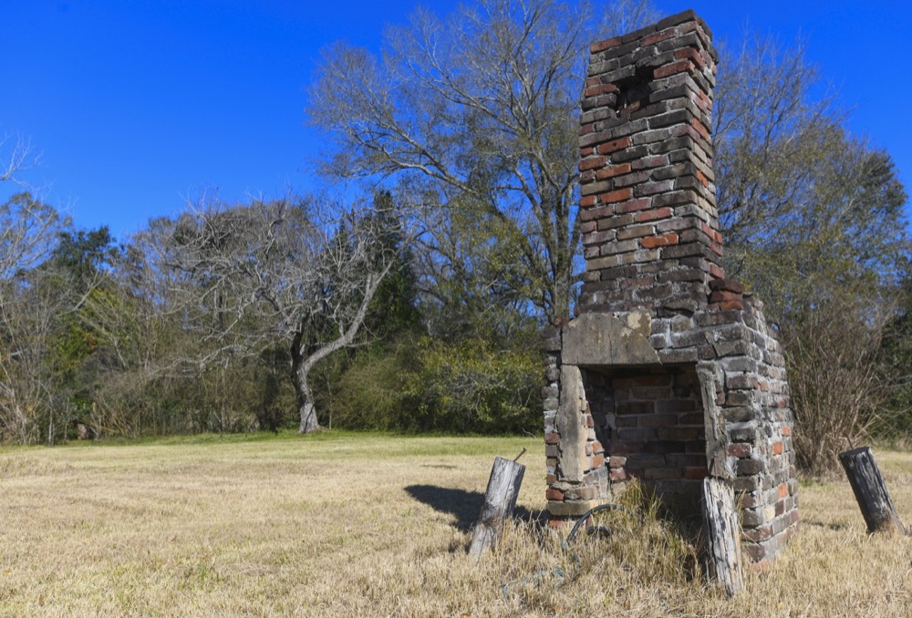 A chimney, the last remaining original structure from the days when survivors of the Clotilda, the last known slave ship brought into the United States, inhabited the area, stands in an abandoned lot in Africatown in Mobile, Ala., on Tuesday, Jan. 29, 2019. After years of watching the steady decline, descendants of the freed slaves who established Africatown are trying to create new ties and, perhaps, rebuild a community that’s in danger of fading away. (AP Photo/Julie Bennett)