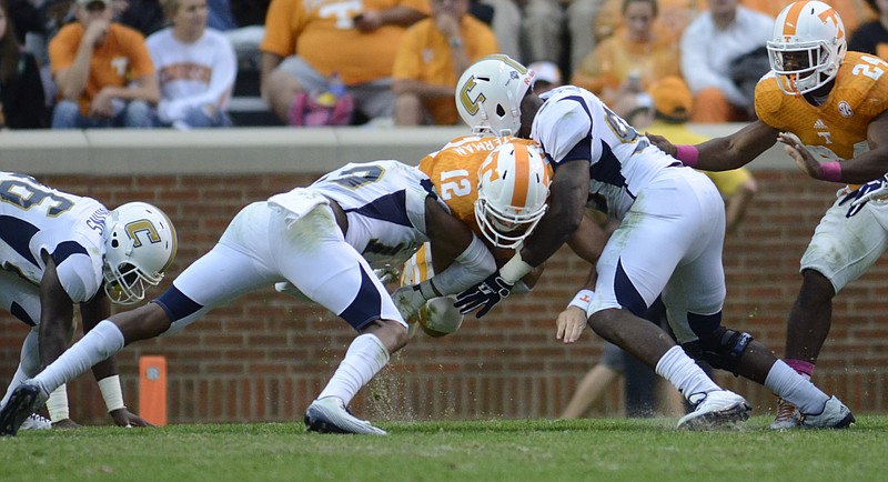 UTC's Tae Davis, left, and Vantrell McMillan bring down Tennessee quarterback Nathan Peterman in October 2014 at Neyland Stadium. The programs will meet at the Knoxville stadium again on Sept. 14 at noon.