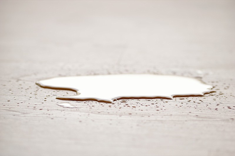 Water puddle on floor dripping from above water tile puddle tile leak / Getty Images