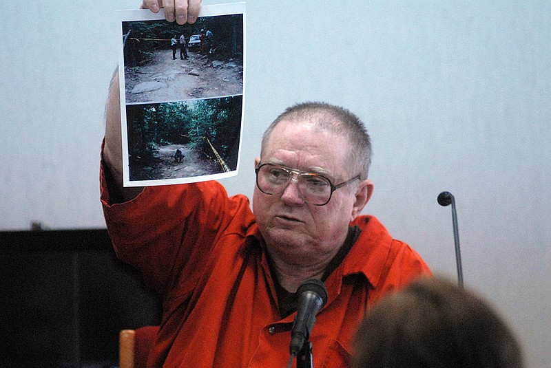 Convicted murderer Frank Casteel holds up a photo during a hearing in 2007 at the Chattanooga-Hamilton County Courts building.