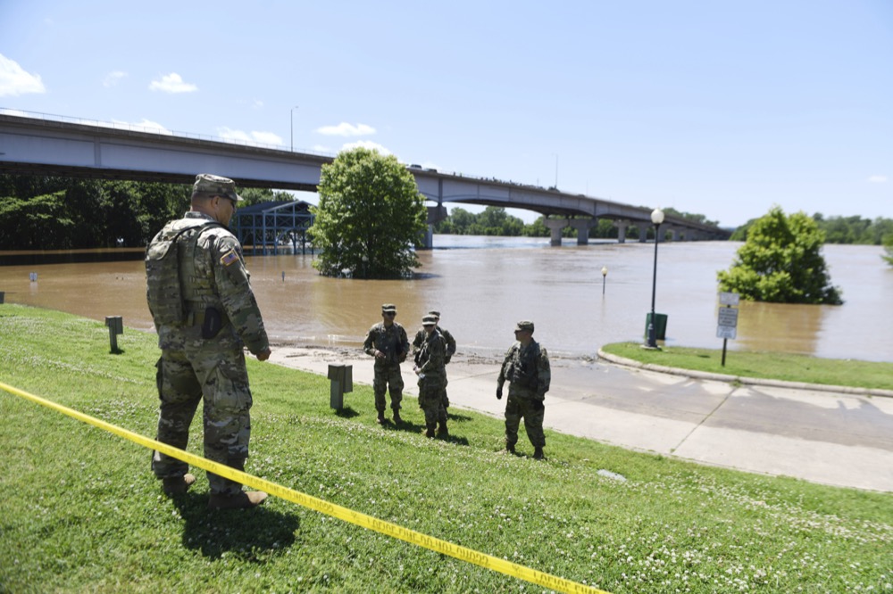 Staff sergeant Curtis Webb, left, and other soldiers with the Arkansas National Guard, 2nd Battalion, 142nd Field Artillery helps stand watch as the Arkansas River floods Harry E. Kelley River Park Thursday, May 30, 2019, in Fort Smith, Ark. The Arkansas National Guard was deployed along the Arkansas River to help residents deal with the flooding. (AP Photo/Michael Woods)