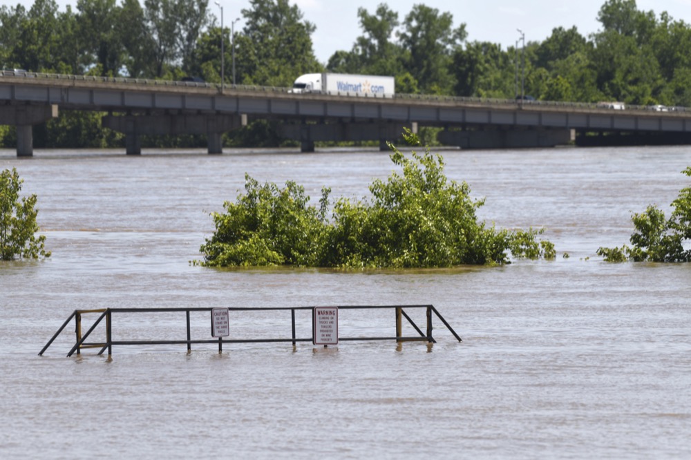 Traffic moves over the I-540 bridge as the Arkansas River floods along Adams Street Thursday, May 30, 2019, in Van Buren, Ark. (AP Photo/Michael Woods)